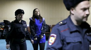 Russian police officers escort suspected jihadist who beheaded a child in Moscow.