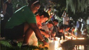 Wendy Frias, from left, and Hector Silva light candles along Lake Eola in Orlando, Sunday, June 12, 2016. The New York natives have made Orlando their home in recent years and came to the vigil for the victims of the Pulse night club tragedy. (AP)