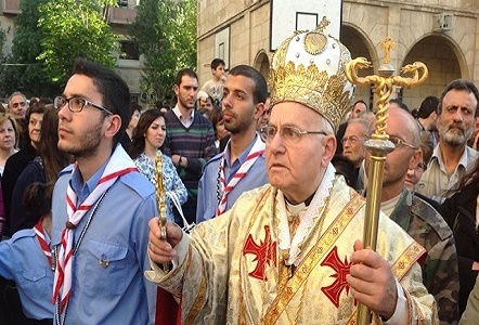 Archbishop Jeanbart leads procession of his war-weary flock. He is angry that the U.S. hasn't done more to protect Christians from the Islamic terrorists.