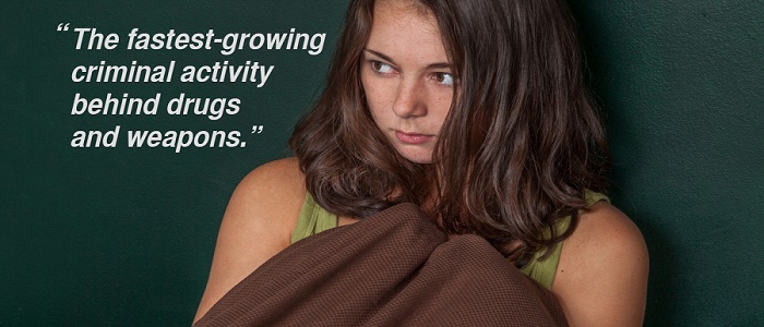 Uncertain teenage girl covering herself with a bed sheet